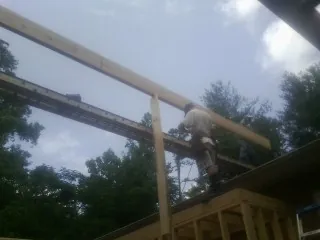 Carpenter setting a ridge beam over a new addition frame — Ice Dam Removal by Roofing Brothers in Spurgeon