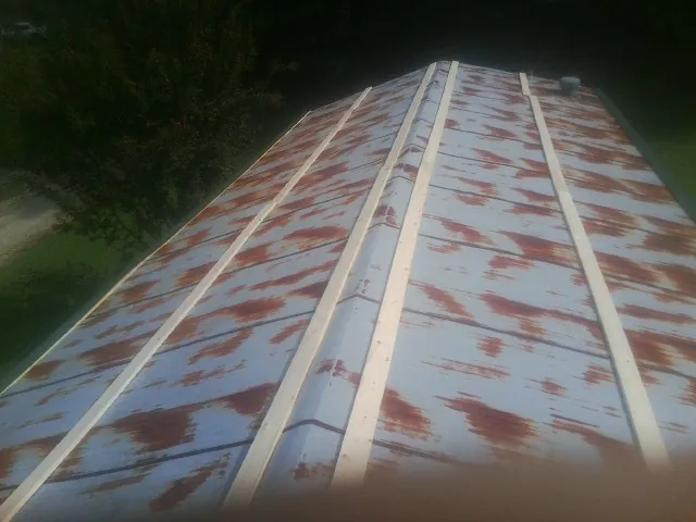 Rusted metal roof panels with new wood purlins before replacement — Storm Damage Roof Repair in Spurgeon by Roofing Brothers