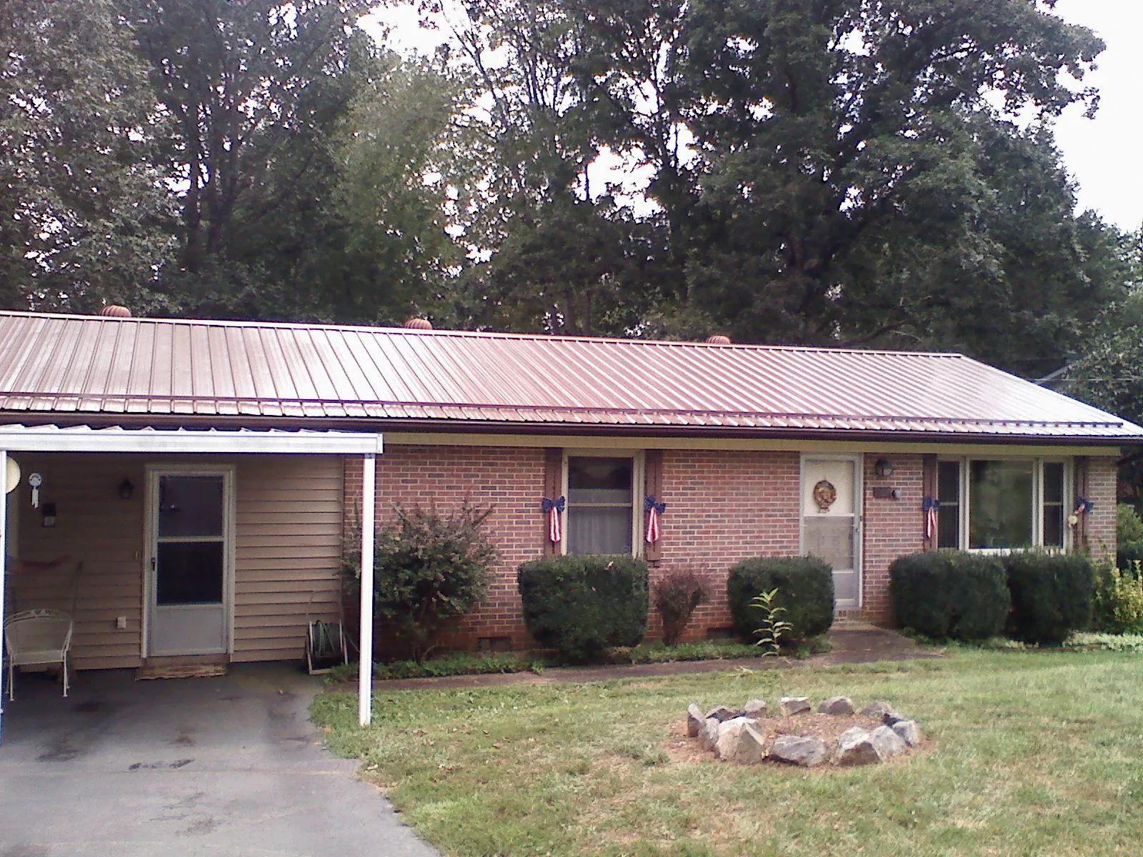 Bronze metal roof and carport on a brick ranch home — Roof Repair work by our crew in Spurgeon